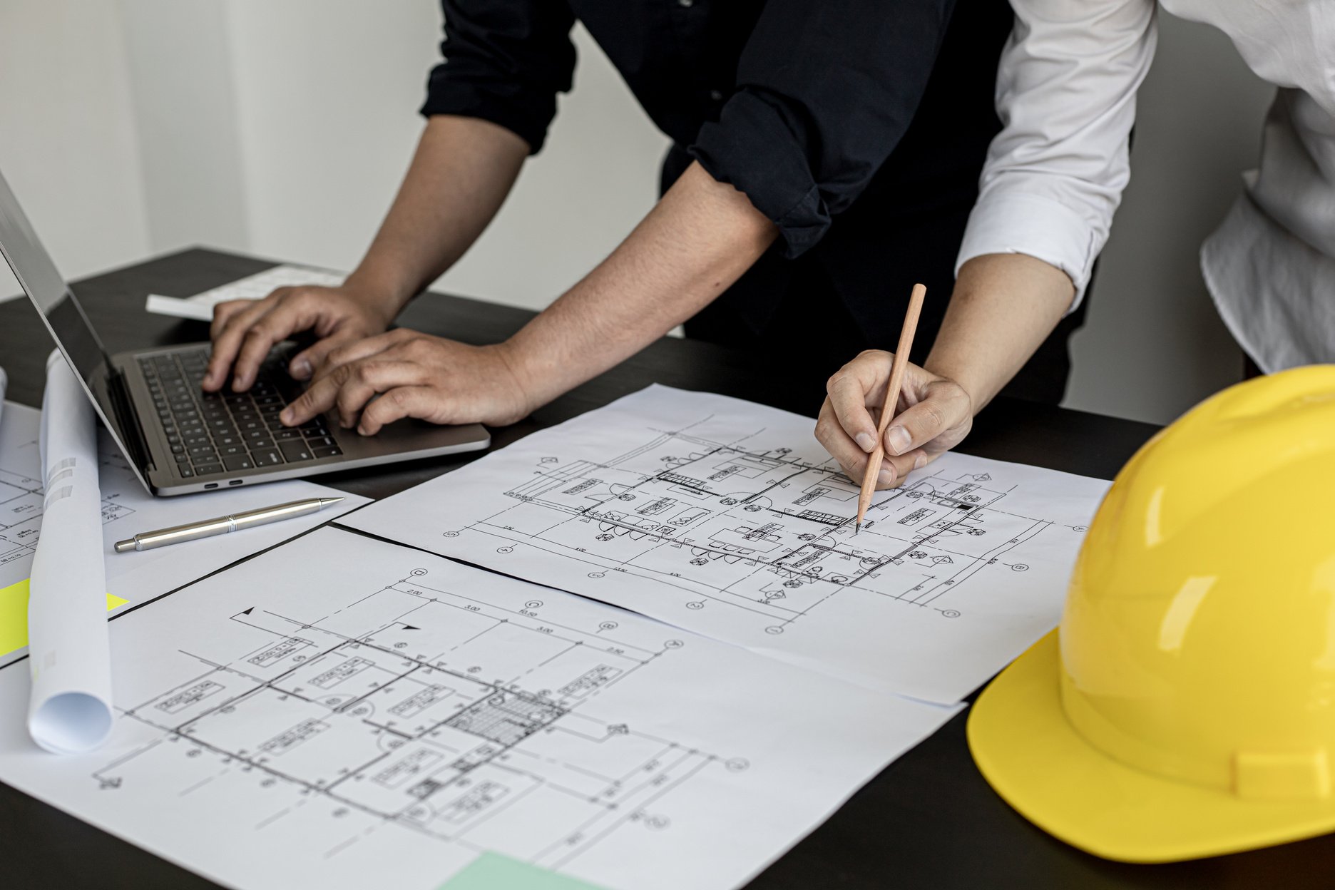 Two architects and engineers are in a meeting to discuss and inspect the house designs to meet the building and construction standards. Interior design and decoration ideas.